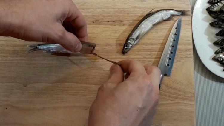 Tăiați capul de pește și scoateți părțile interioare.