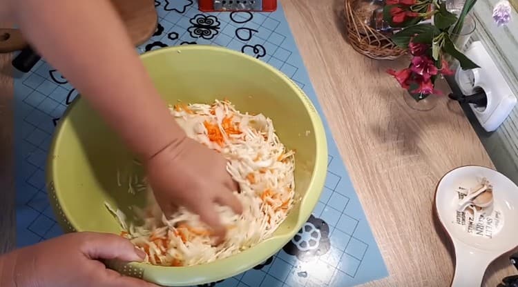 Vi knådar grönsakerna väl med händerna så att de släpper juicen.