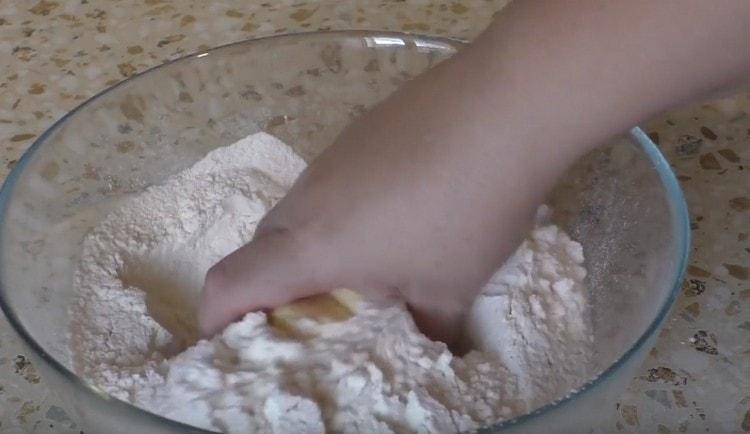 Fügen Sie die Butter hinzu und mahlen Sie sie mit Mehl zu Krümeln.