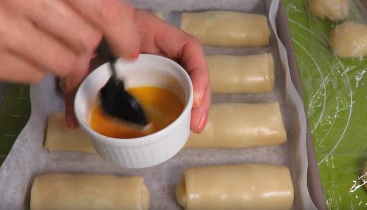 Battre le jaune et graisser les tartes.