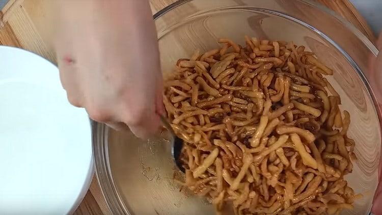 Nalijte sirup do smaženého těsta a rychle promíchejte.