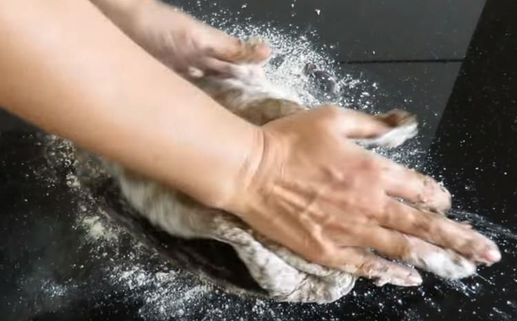 Se frământă bine aluatul pe o suprafață inflorită.