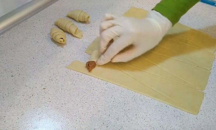 Después de hacer una pequeña incisión en el borde de la masa, la envolvemos en diferentes direcciones, como si envolviera la leche condensada.