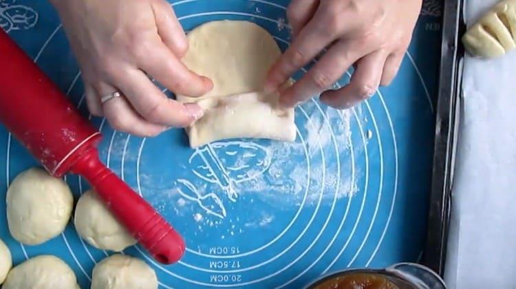 Întindem gemul pe o jumătate din aluat, îl învelim astfel încât cealaltă jumătate să rămână liberă.