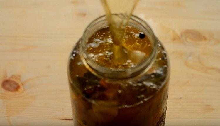 Punem bucățile de macrou într-un borcan și turnăm marinata.