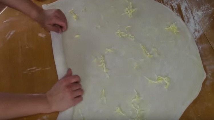 Gnid et andet smør på den rullede dej og rull det op.