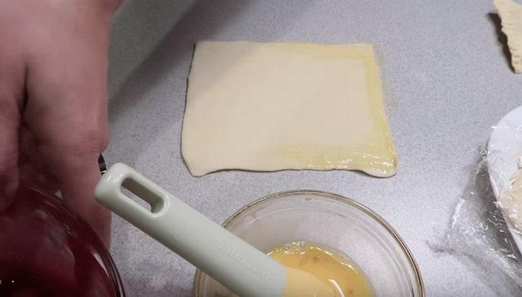 Смажете половината детайл около периметъра с разбито яйце.