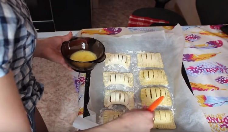 Поставете подготвените слоеве върху хартия за печене, застлана с хартия за печене и намажете с яйце.