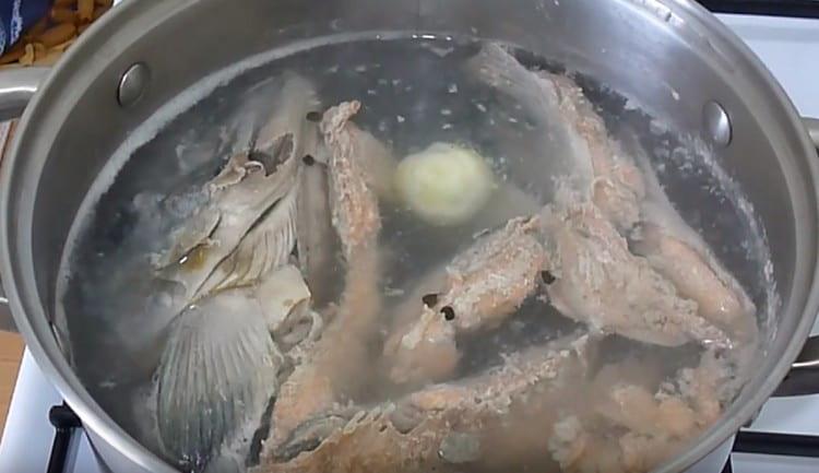 Zwiebel und Pfefferkörner in die Brühe geben.