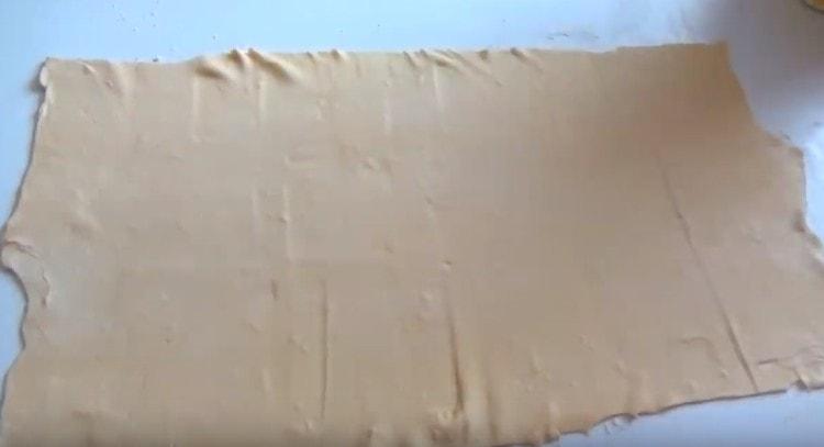 Разточете тестото и го нарежете наполовина.