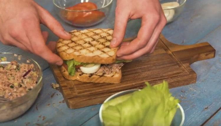 Acoperiți sandvișul cu o a doua bucată de pâine.