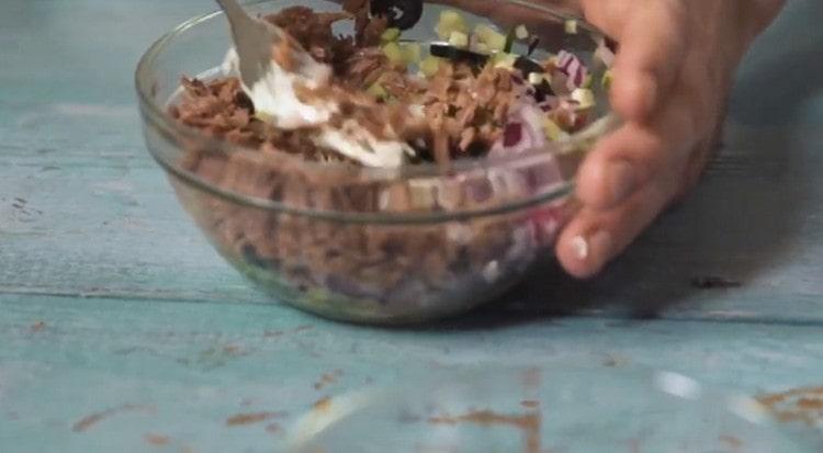 Adăugați maioneză, castraveți, măsline, amestecați.