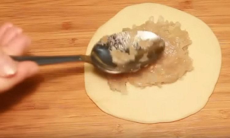 Estiramos cada pieza de masa con un rodillo y colocamos el relleno de carne en el centro.