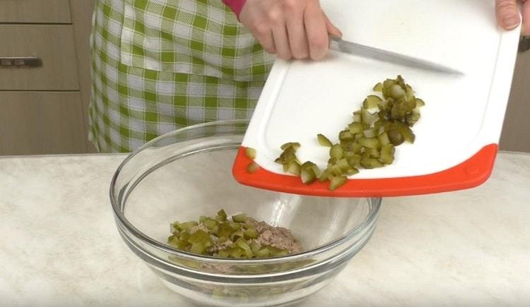 Нарязваме ситно нарязаните краставици и добавяме треска към черния дроб.