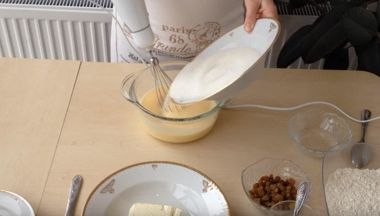 Adăugați zahăr în ouă.