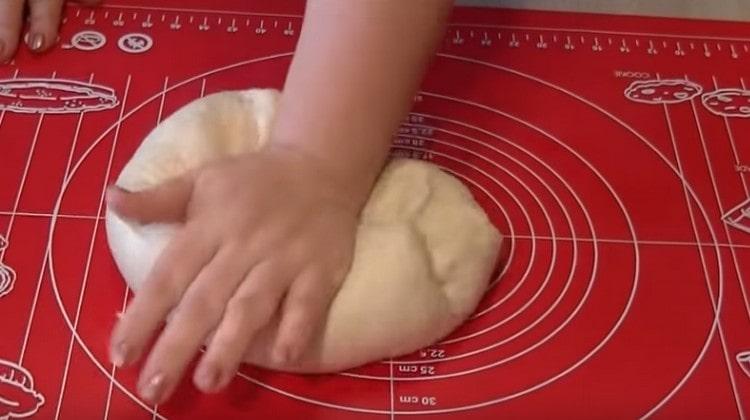 Vi ælte den hævede dej og placer den derefter i en skål igen.