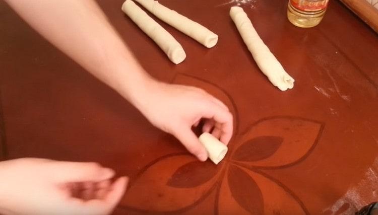 Scoțând aluatul din frigider, tăiați cârnații în felii porționate.