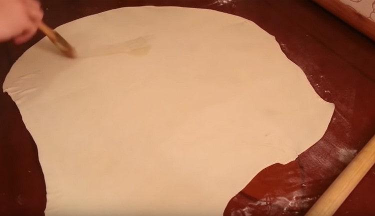 Cu ajutorul unei pensule, ungeți aluatul cu ulei vegetal.