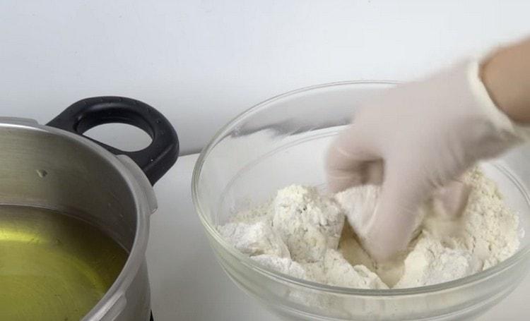 В тиган загрейте растителното масло и завийте рибата в брашно.