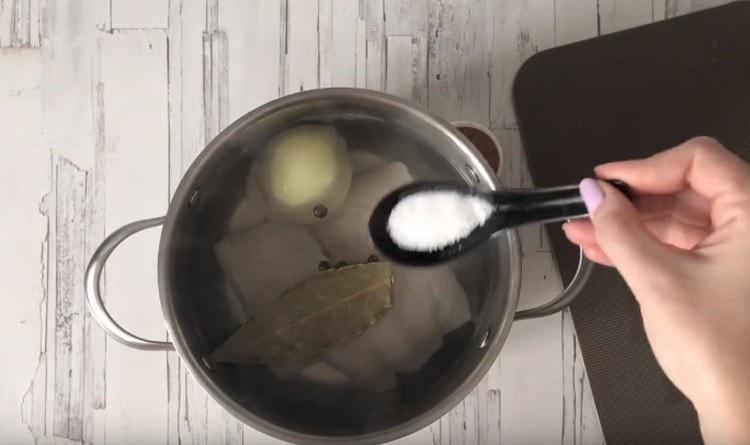 Dans la casserole, nous répartissons le poisson, les oignons, le céleri, le poivre dans une casserole, le laurier, ajoutez du sel.