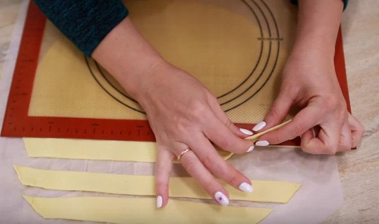 Разточете бутер тестото тънко и нарежете на тънки дълги ивици.