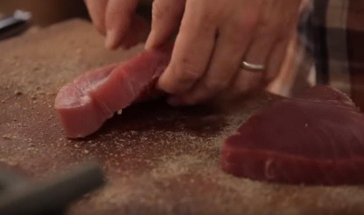 Turnați condimentele tocate pe tablă și rotiți fripturile în ele.