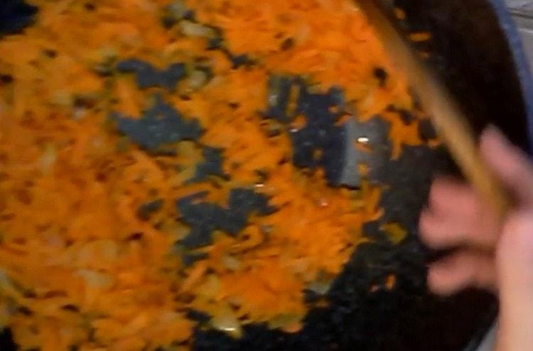 Zwiebeln mit Karotten in einer Pfanne abseihen.