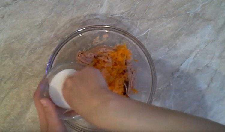 Fügen Sie Karotten mit Zwiebeln, Salz und Pfeffer zum resultierenden Hackfleisch hinzu.