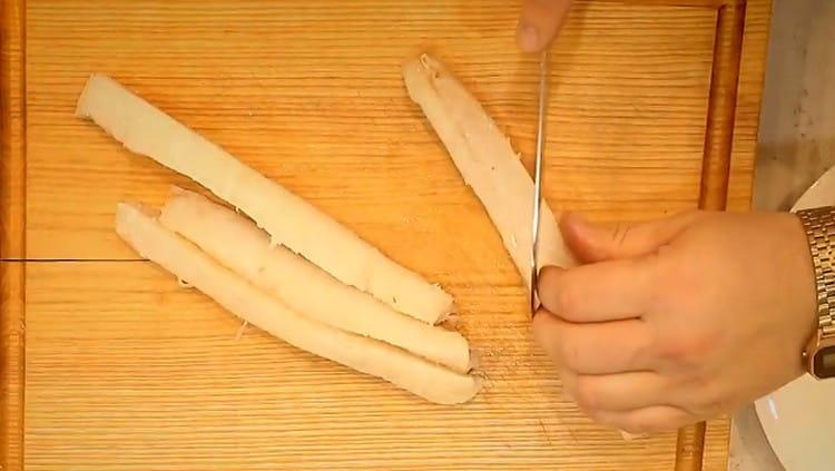 File de cod tăiat în fâșii lungi, fiecare fiind tăiat în jumătate oblic.