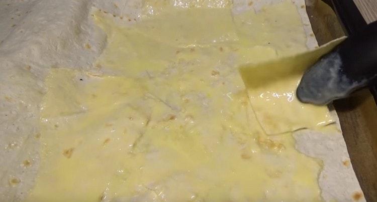 Déchirez une autre feuille de pain pita en morceaux et, en les plongeant dans un mélange kéfir-œuf, étalez-les sur un gros pain pita.