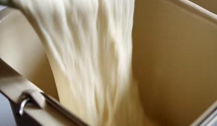 Разпределяме тестото в кофа на машина за хляб.