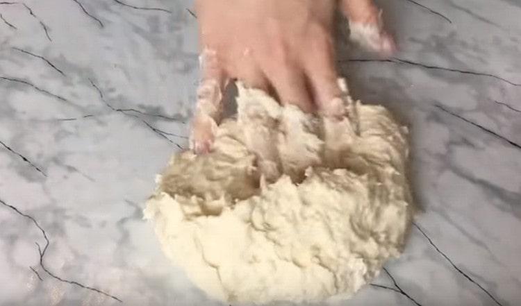 Then carefully knead the sticky dough on the table.