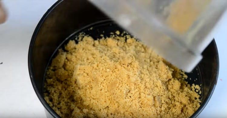 Spred den resulterende masse fra cookies og smør i en delt bagefad.