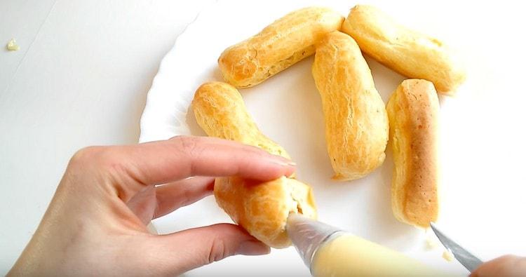Utilitzant una bossa de pastisseria amb broquet, ompliu els eclairs de crema.