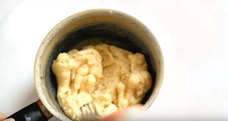 Aboqueu la farina al líquid bullint i barregeu-la ràpidament per fer la massa.