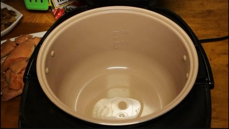 Varm skålen op for at koge lyserød laks i en langsom komfur