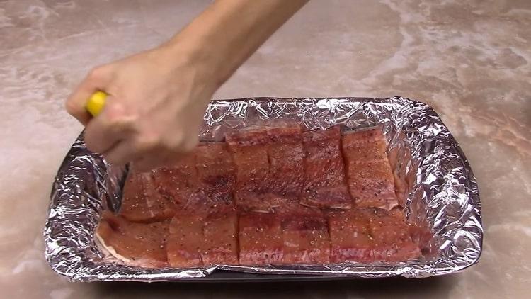 ضغط الليمون لصنع سمك السلمون الوردي في صلصة دسم