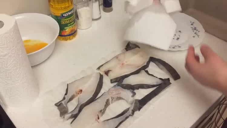 Assecar el peix per cuinar el bistec de bacallà en una paella.