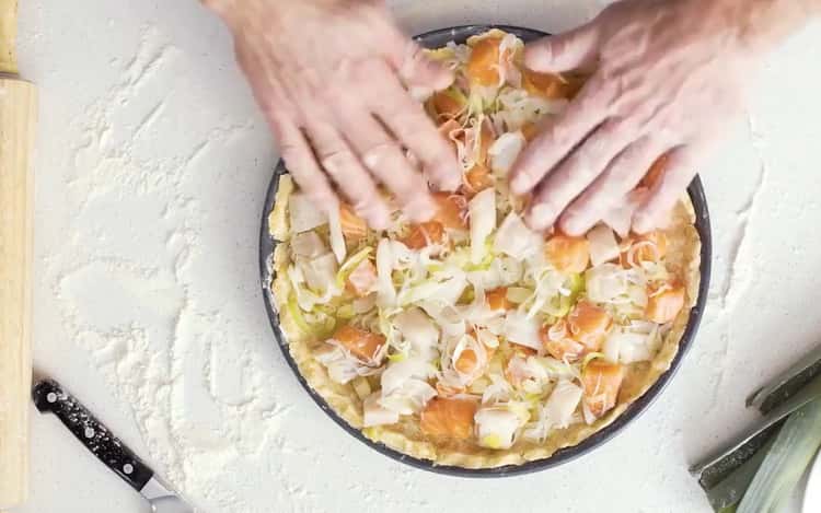 För att förbereda quiche med fisk, lägg fyllningen på degen