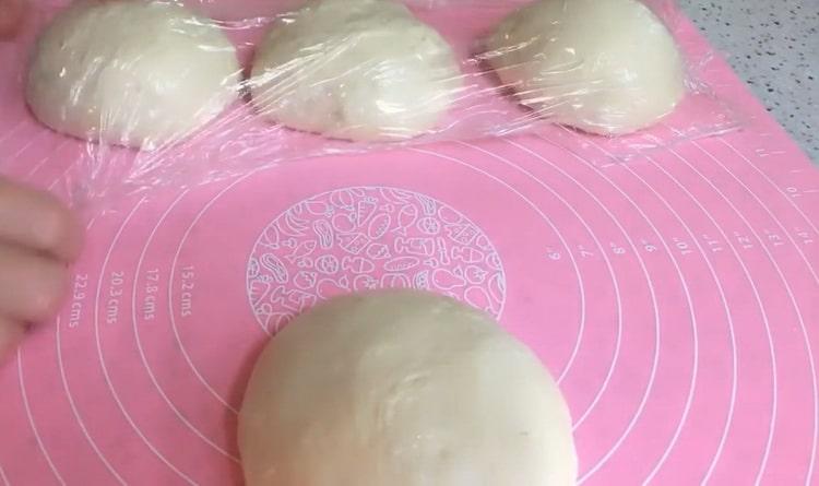 Per fer pastissos plans de llevat, dividiu la massa en una paella.