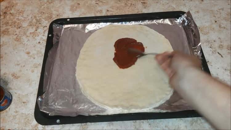 Upang makagawa ng pizza na may sausage at keso, maghanda ng tomato paste