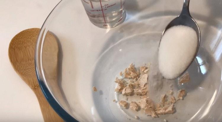 Într-un bol cu drojdie sfărâmată. adaugă zahăr la ele.