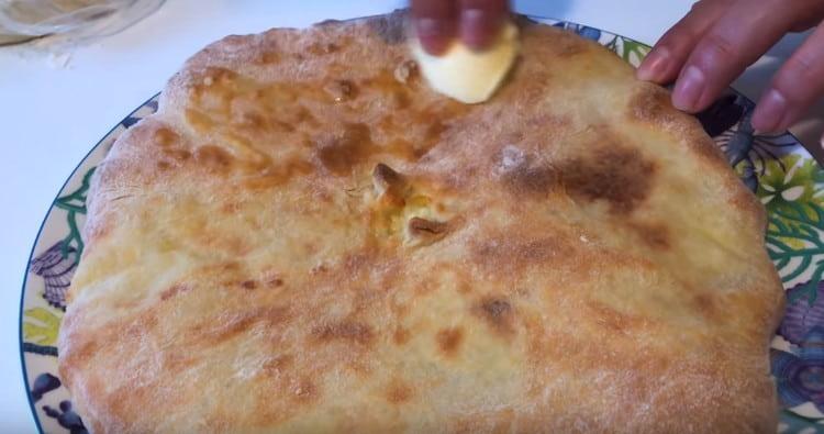 Khachapuri gătit la cuptor cât este încă fierbinte trebuie uns cu o bucată de unt.