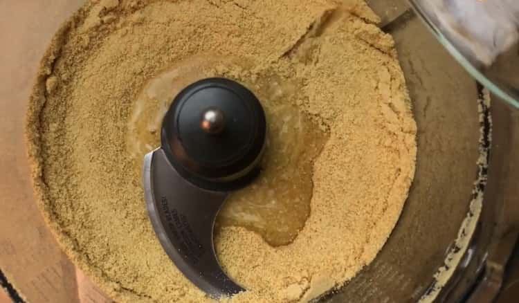 Um einen klassischen Käsekuchen zuzubereiten, mischen Sie Kekse mit Butter