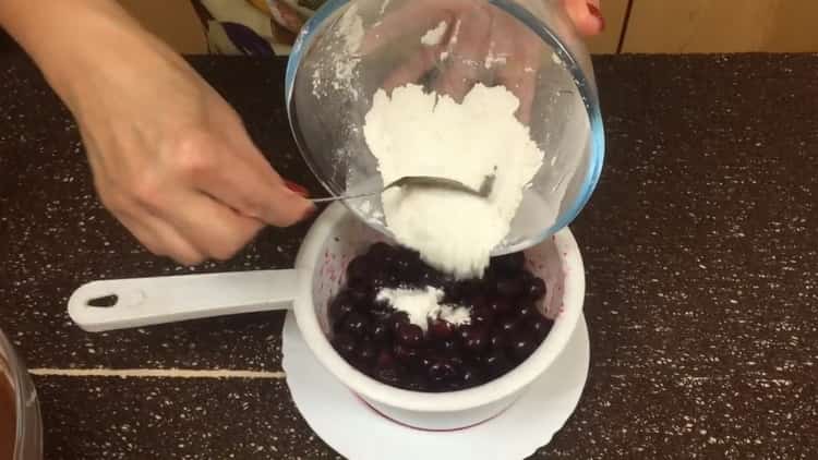 For at fremstille en chokolademuffin med kirsebær, drys kirsebæret med mel