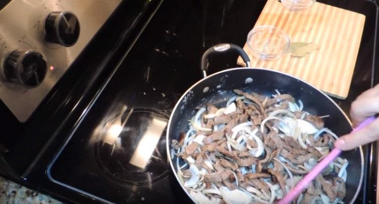 Mélanger la viande avec les oignons, faire frire jusqu'à ce qu'il soit transparent.