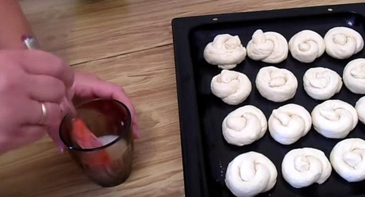 Намажете кифличките със смес от яйца и мляко.