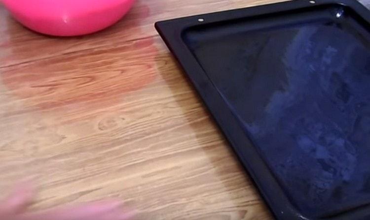 Намазваме лист за печене с растително масло, работна повърхност също.