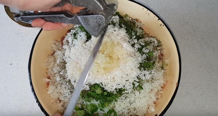 Kombinujte mleté maso, rýži, česnek, nakrájenou cibuli a bylinky.