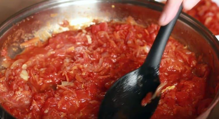 Взимаме половината от зеленчуковата маса и изравняваме втората половина по дъното на тигана.